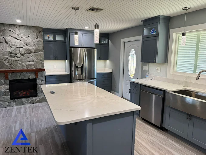 ZenTek Southwest Florida kitchen remodel with deep blue cabinetry, a stone fireplace, and a waterfall island
